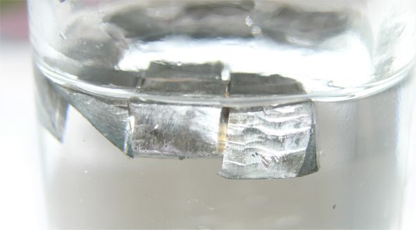 Pieces of lithium metal floating in clear oil