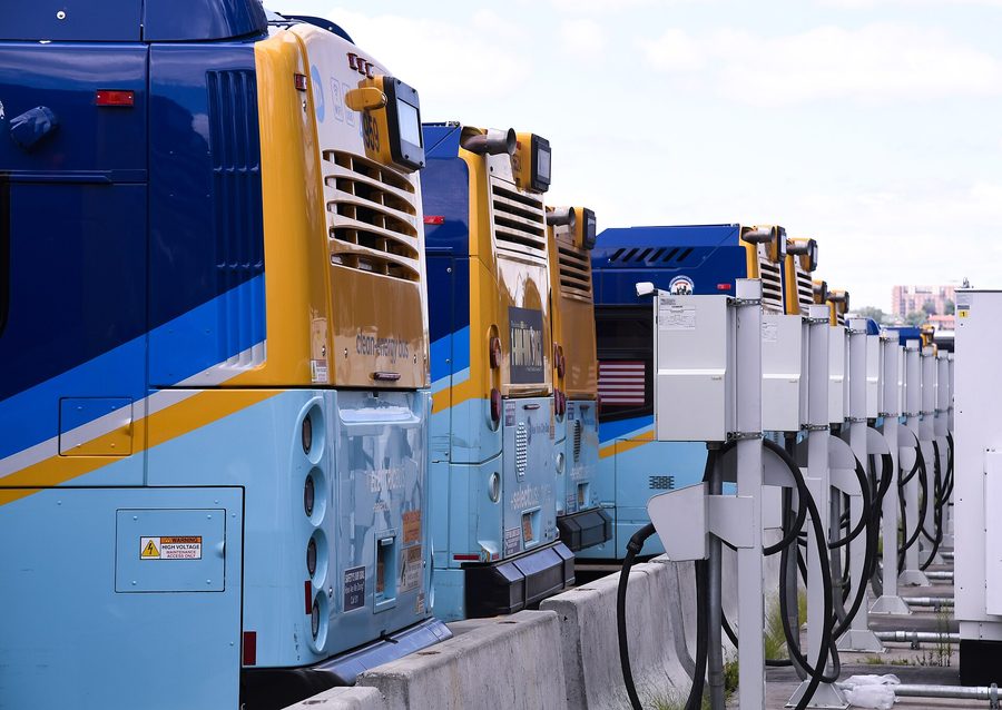Electric buses plugged into charging points at a New York depot