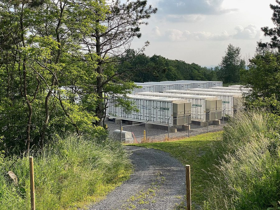 Rows of battery storage containers in a green rural landscape